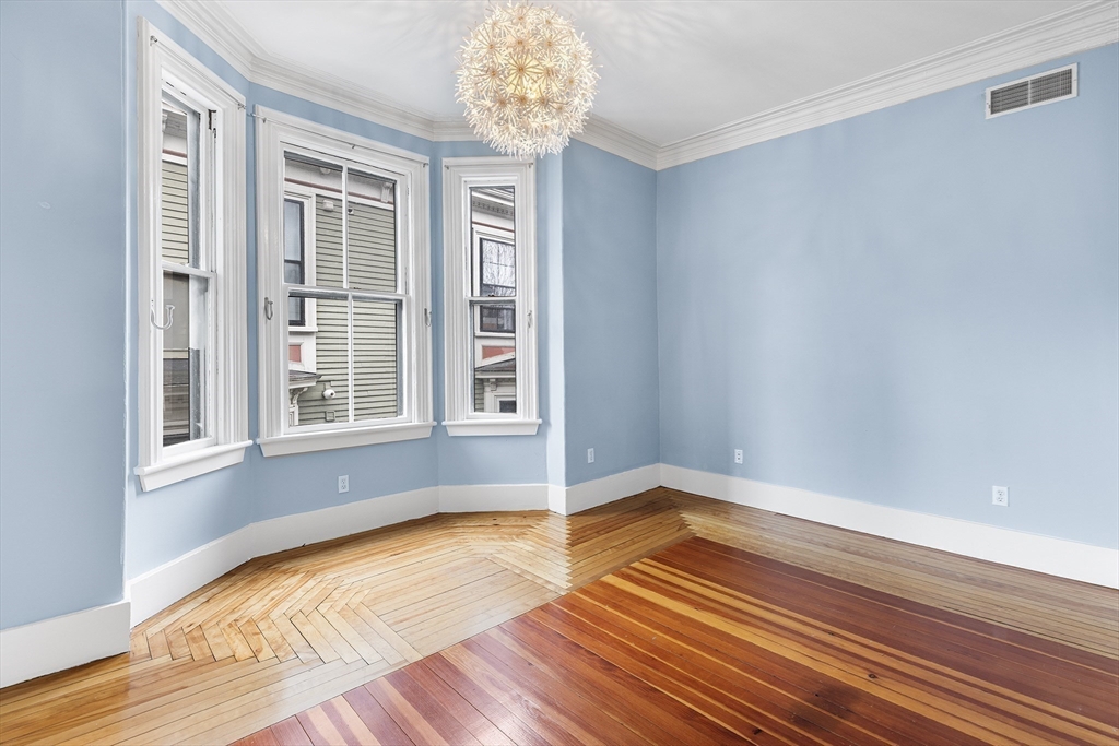 398 Broadway, Unit 2A Somerville, MA 02145 - Photo 15 of 25 a view of empty room with wooden floor and fan