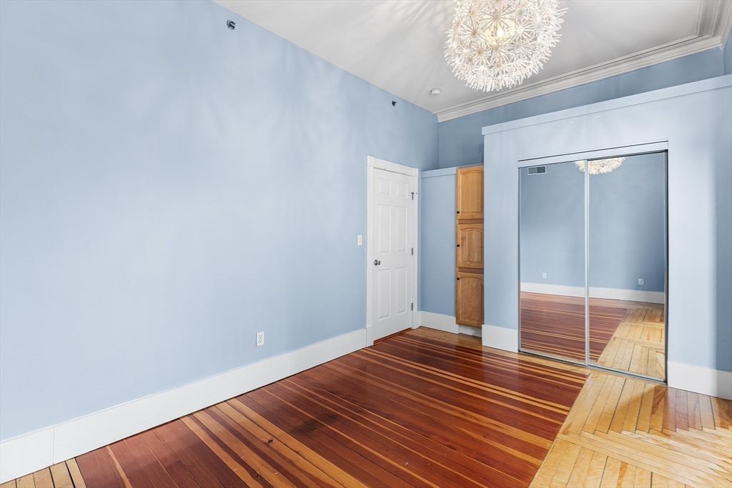 398 Broadway, Unit 2A Somerville, MA 02145 - Photo 16 of 25 a view of a room with wooden floor and a hallway