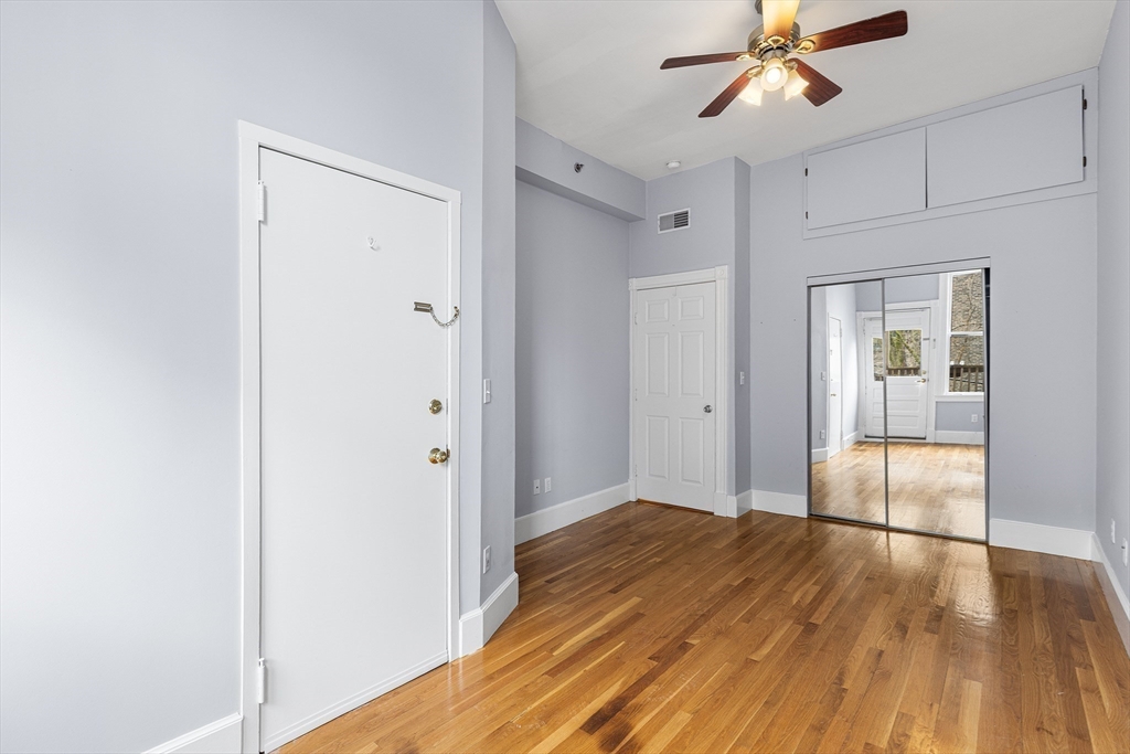 398 Broadway, Unit 2A Somerville, MA 02145 - Photo 18 of 25 a view of empty room with wooden floor and fan