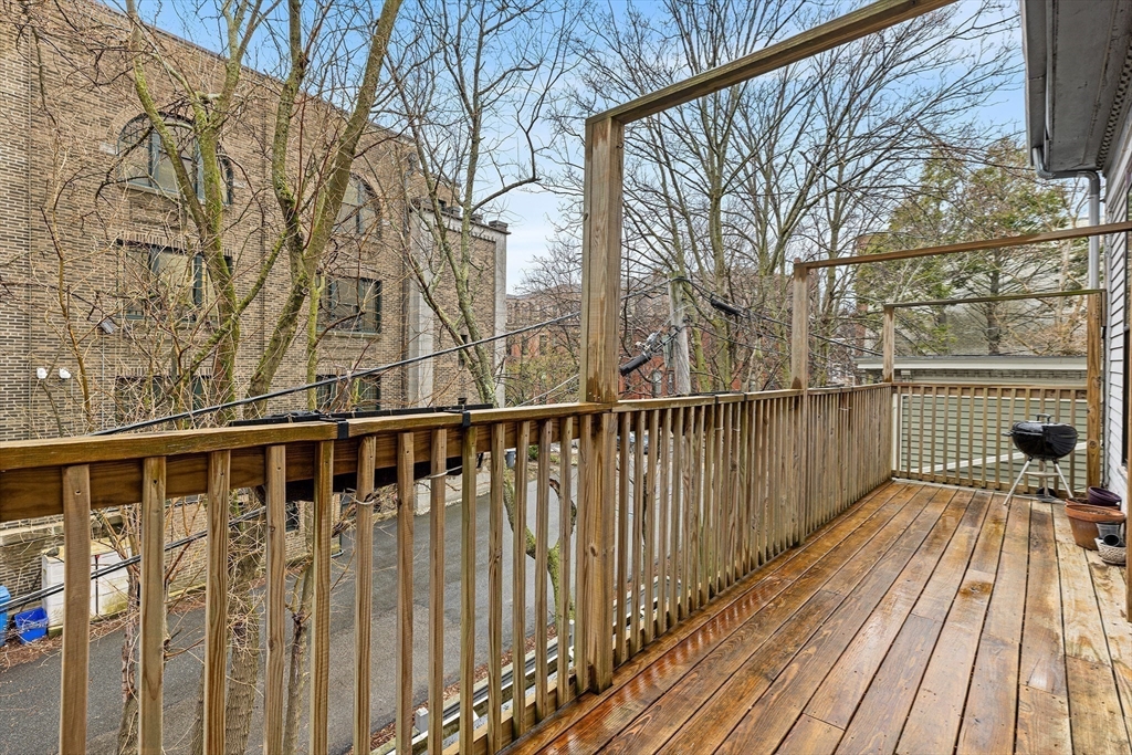 398 Broadway, Unit 2A Somerville, MA 02145 - Photo 22 of 25 a view of balcony with wooden floor and fence