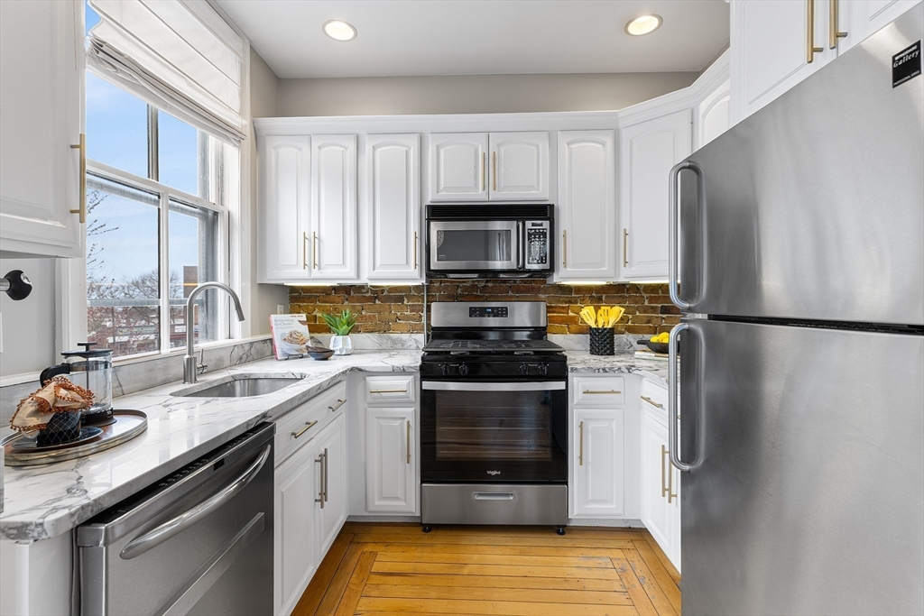 398 Broadway, Unit 2A Somerville, MA 02145 - Photo 7 of 25 a kitchen with a sink stove and refrigerator
