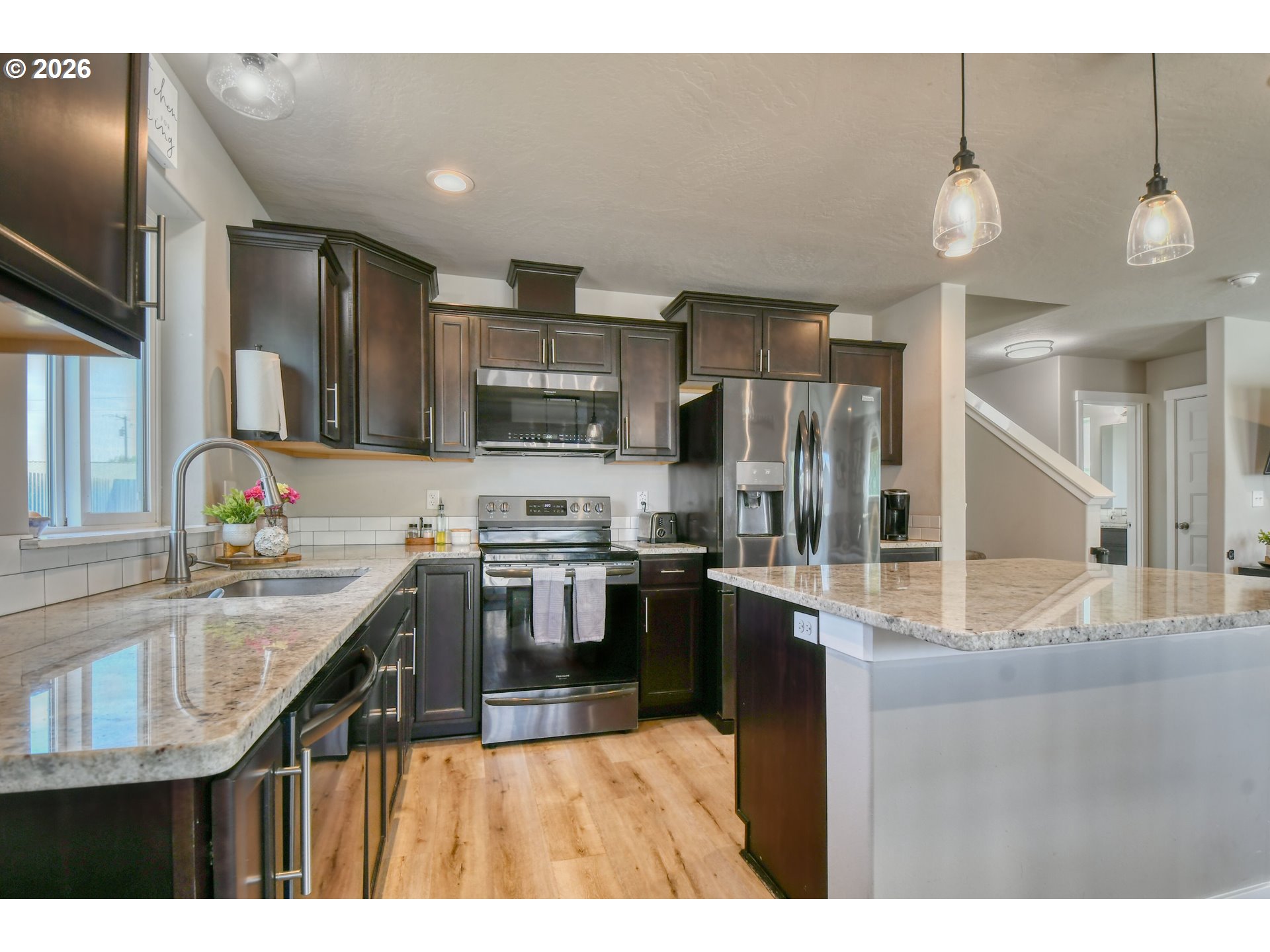233 East Jefferson Street Athena, OR 97813 - Photo 11 of 36 a kitchen with kitchen island granite countertop stainless steel appliances and a counter top space