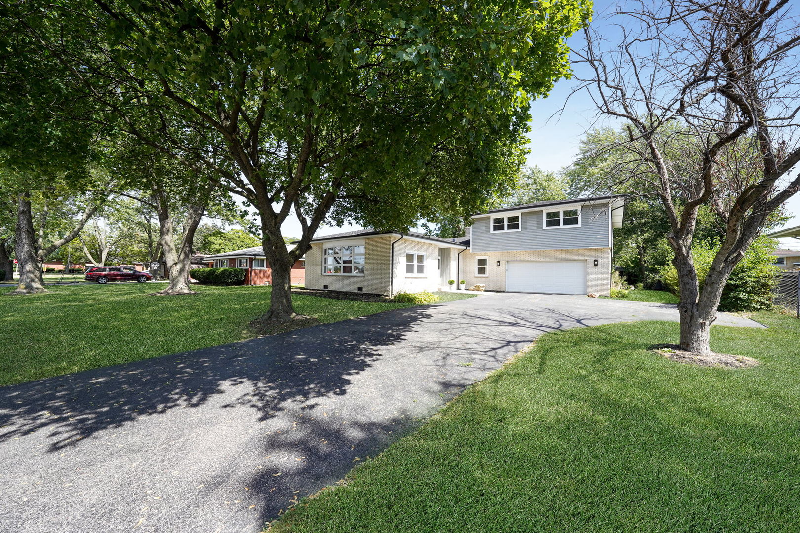 12801 South Ridgeland Avenue Palos Heights, IL 60463 - Photo 2 of 59 a view of a white house in front of a big yard with large trees