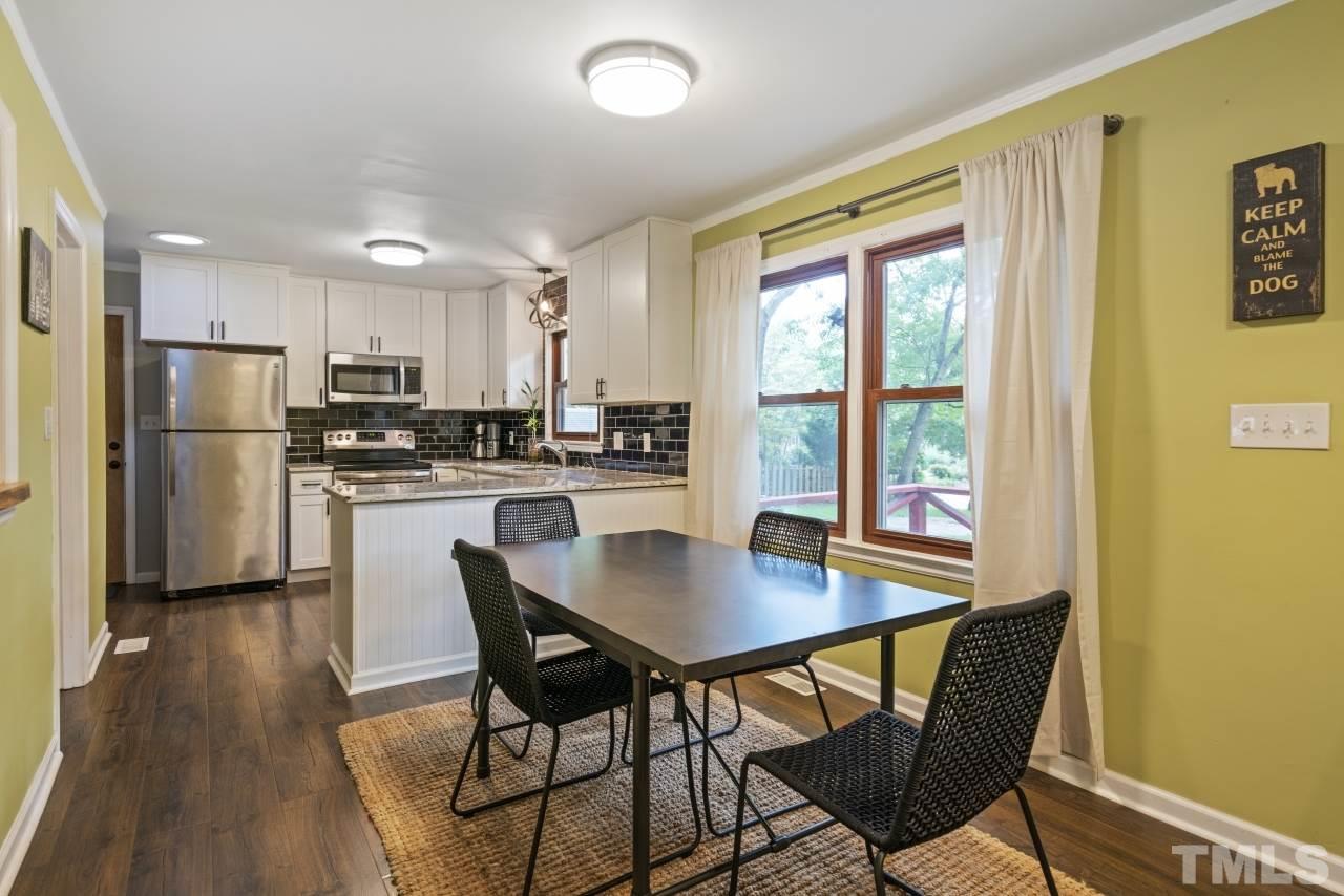 1205 Keith Drive Cary, NC 27511 - Photo 12 of 29 a kitchen with a table chairs refrigerator and cabinets