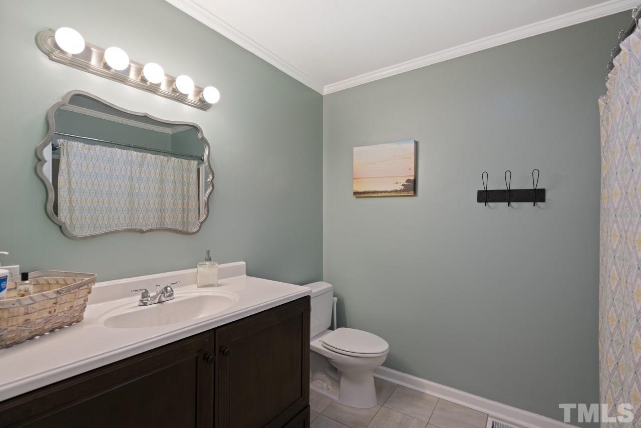 1205 Keith Drive Cary, NC 27511 - Photo 18 of 29 a bathroom with a sink a toilet and a mirror