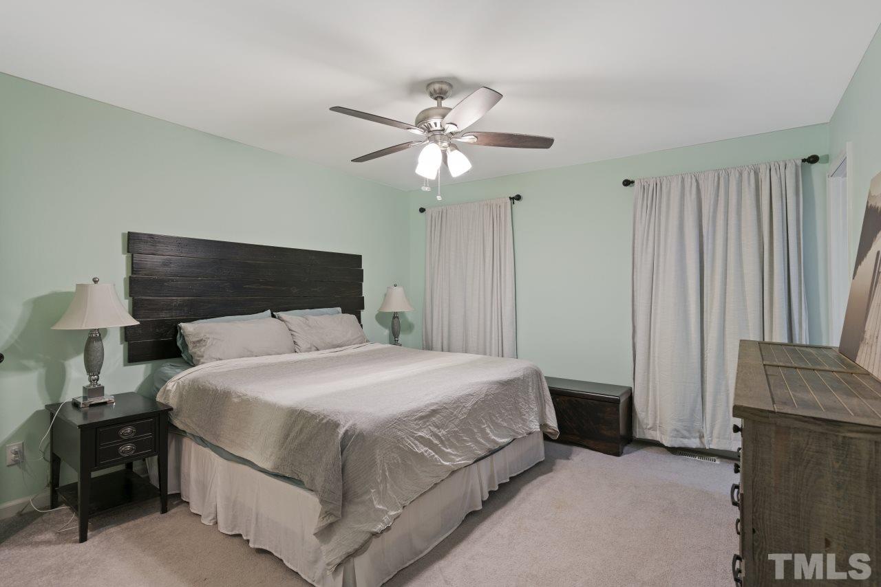 1205 Keith Drive Cary, NC 27511 - Photo 22 of 29 a bedroom with a bed and a chandelier