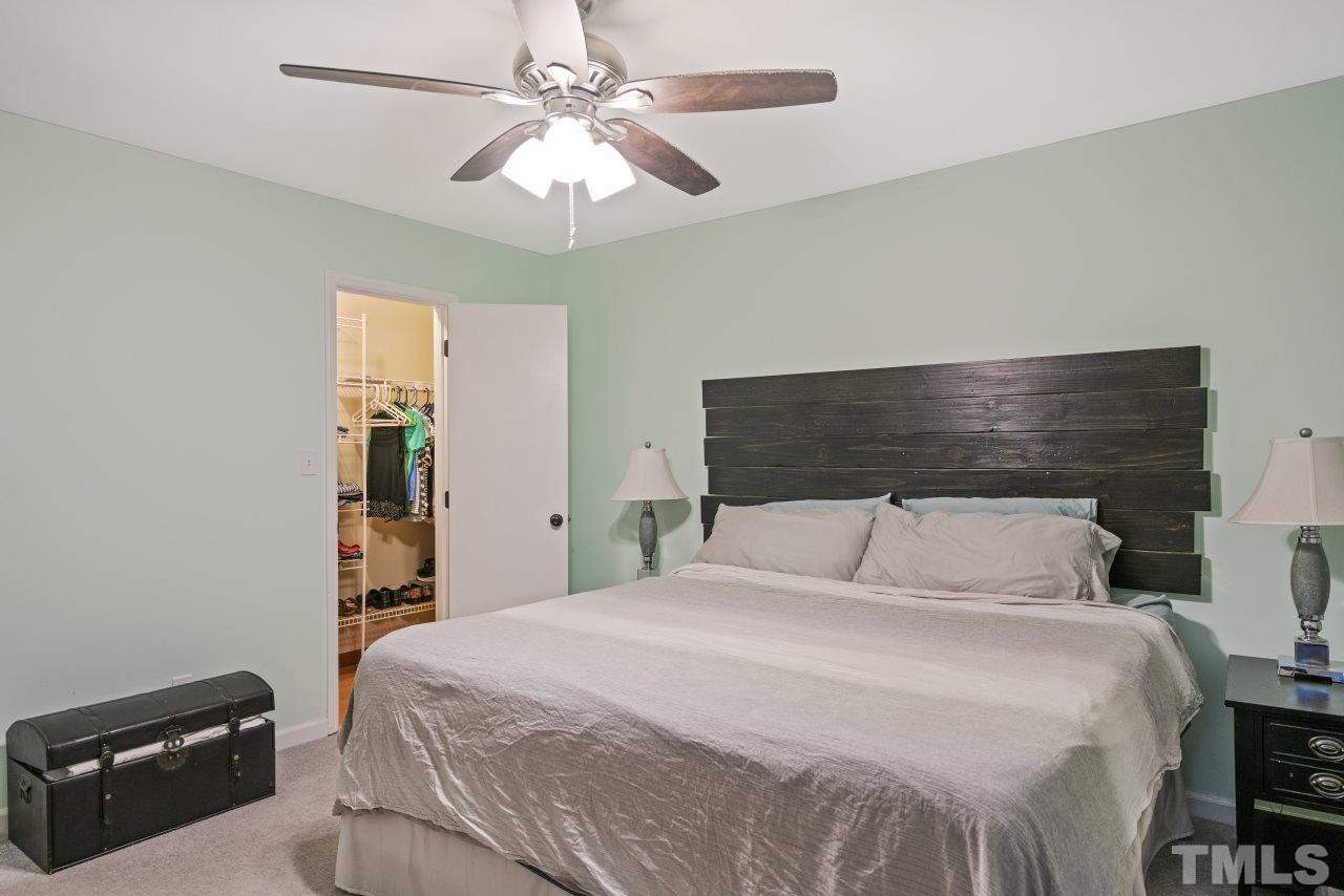 1205 Keith Drive Cary, NC 27511 - Photo 23 of 29 a bedroom with a bed and a chandelier
