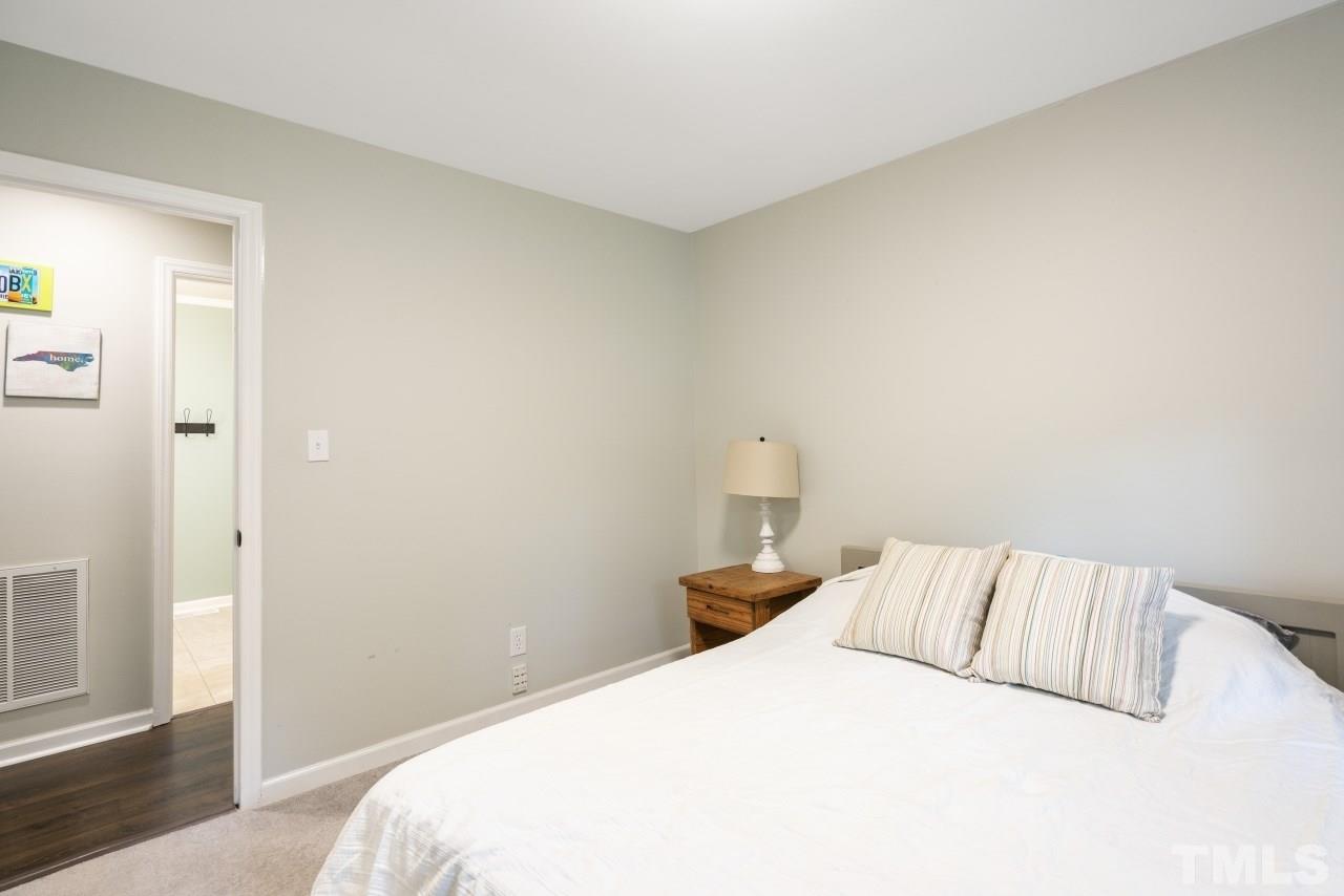 1205 Keith Drive Cary, NC 27511 - Photo 28 of 29 a bedroom with a bed and a night stand