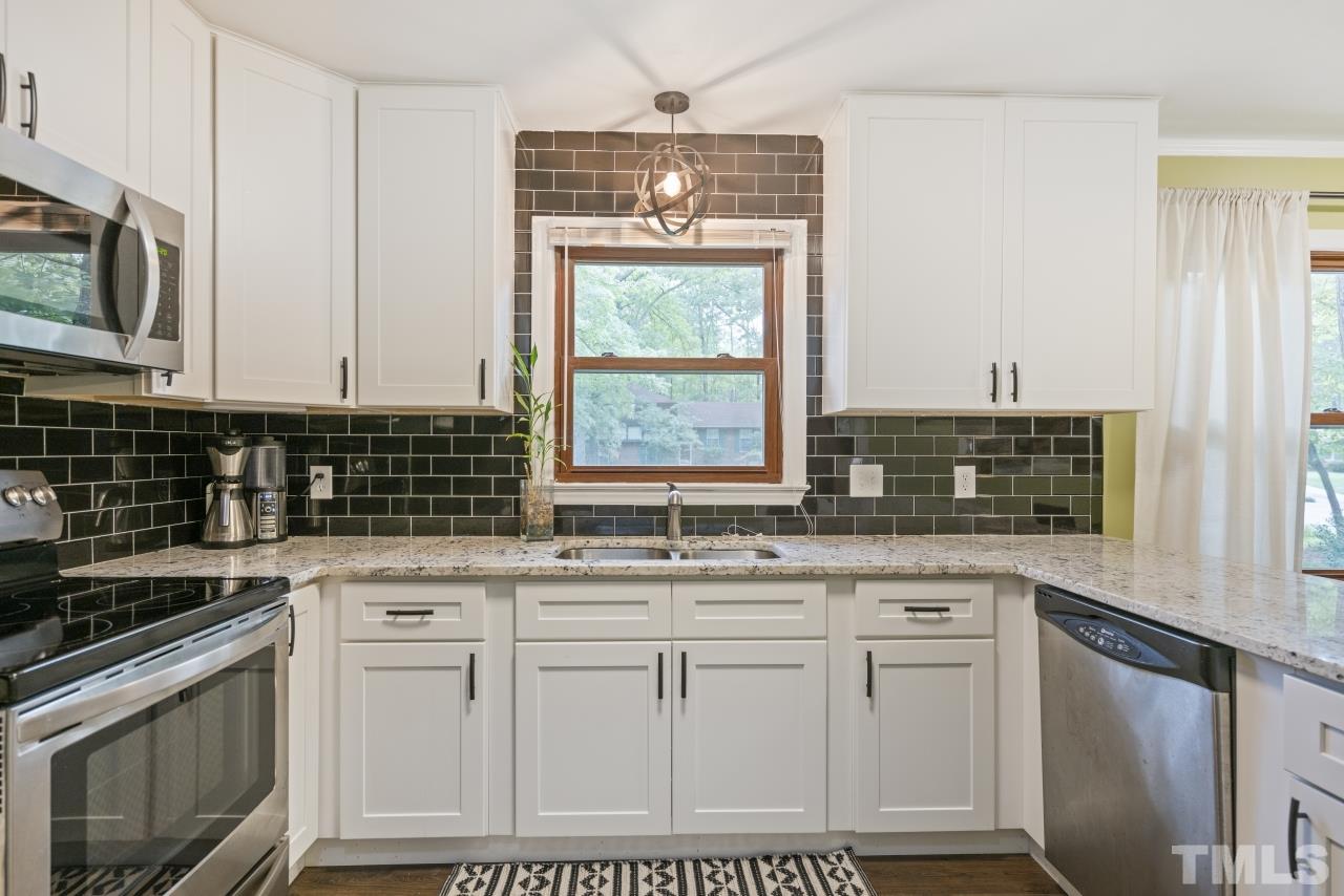1205 Keith Drive Cary, NC 27511 - Photo 7 of 29 a kitchen with stainless steel appliances granite countertop a sink stove and microwave