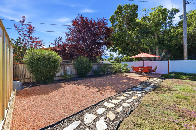 1180 North 400 East Bountiful, UT 84010 - Photo 37 of 50 Landscaped backyard featuring an irregular flagstone pathway, a red gravel area, and a private wooden deck