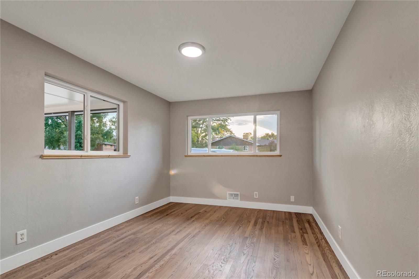 3880 Allison Street Wheat Ridge, CO 80033 - Photo 14 of 25 an empty room with wooden floor and windows