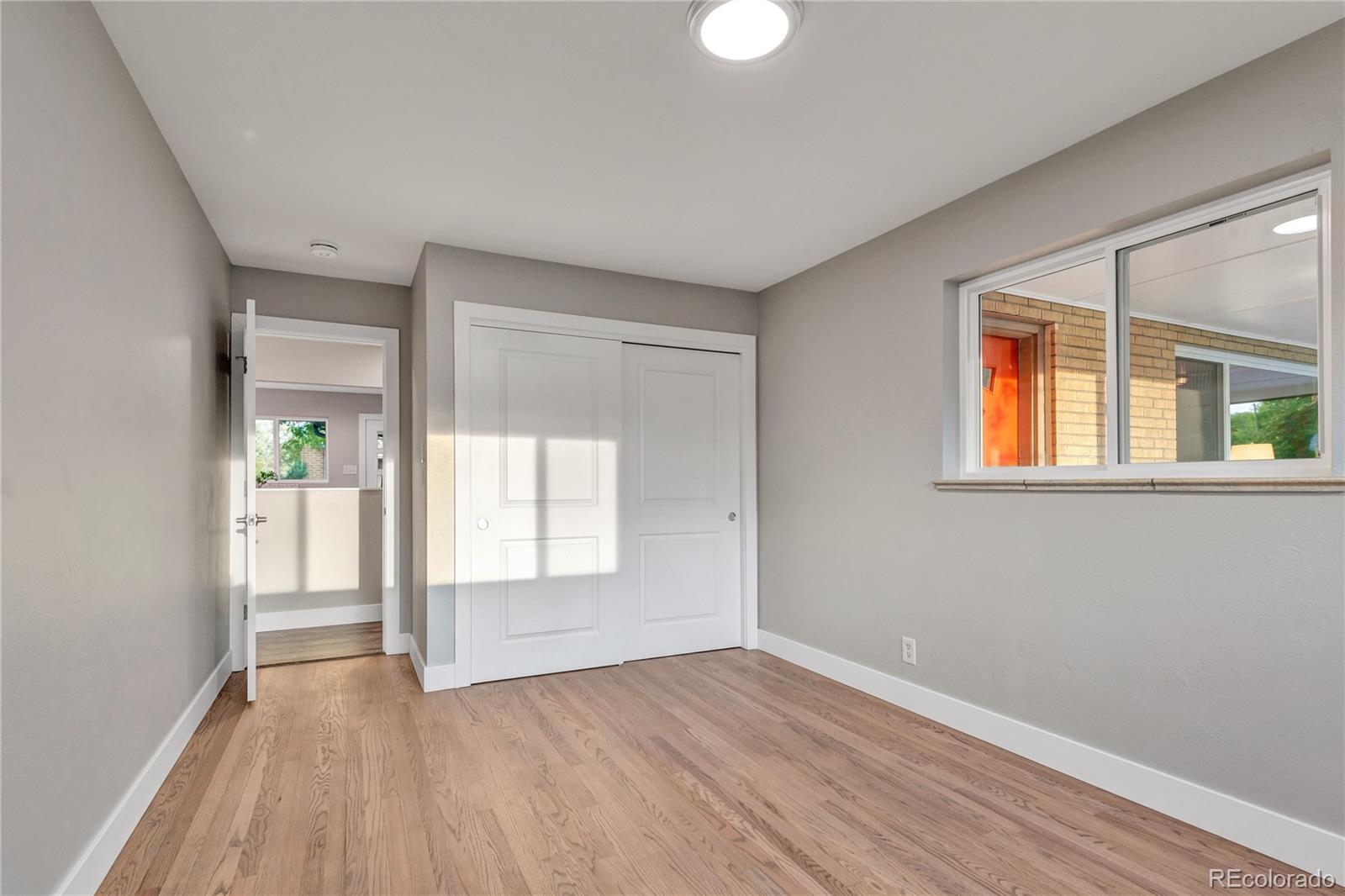 3880 Allison Street Wheat Ridge, CO 80033 - Photo 15 of 25 a view of an empty room with wooden floor and a window