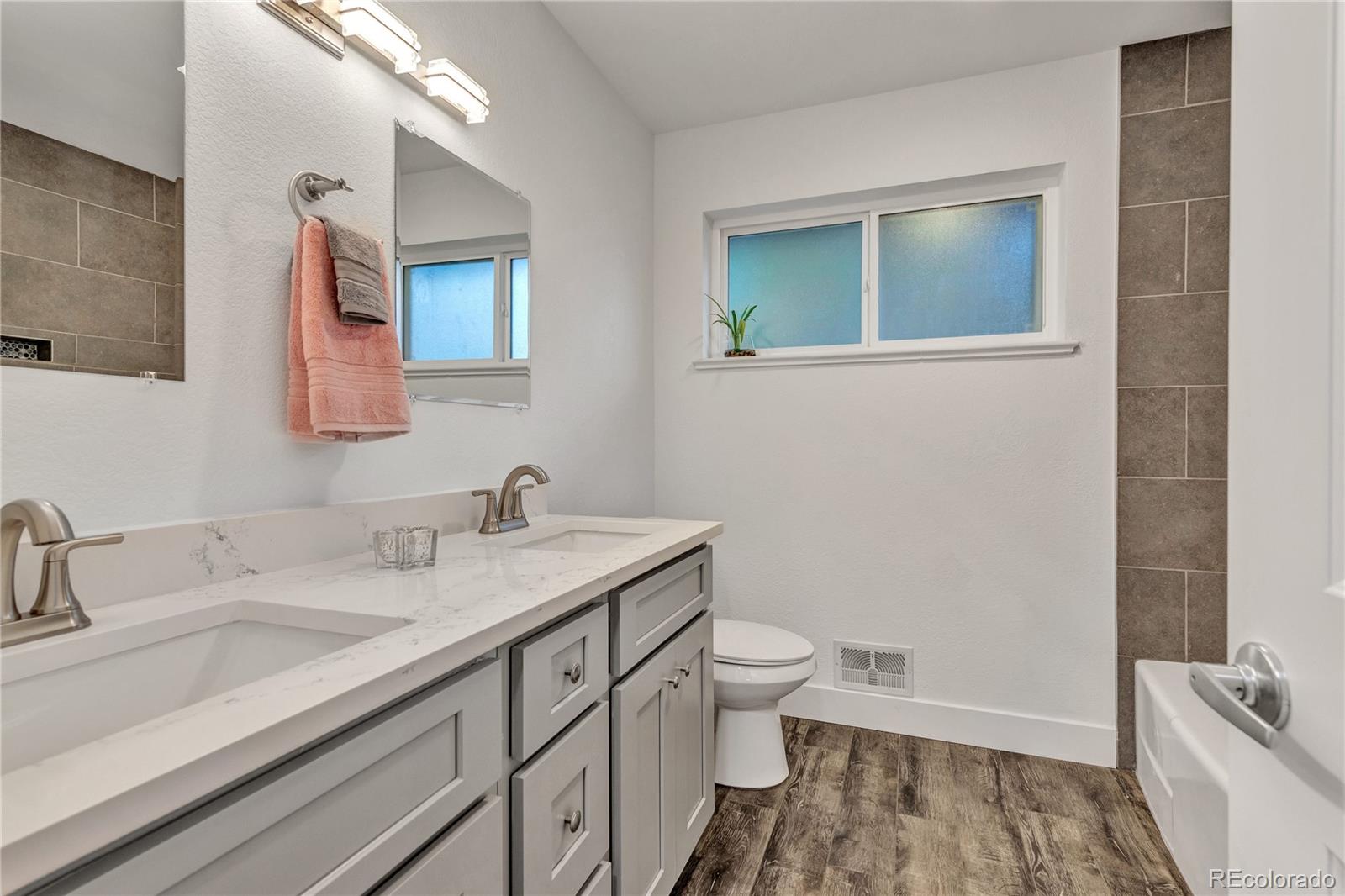 3880 Allison Street Wheat Ridge, CO 80033 - Photo 16 of 25 a bathroom with a granite countertop sink and a mirror