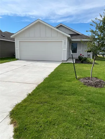 a front view of a house with a yard and trees