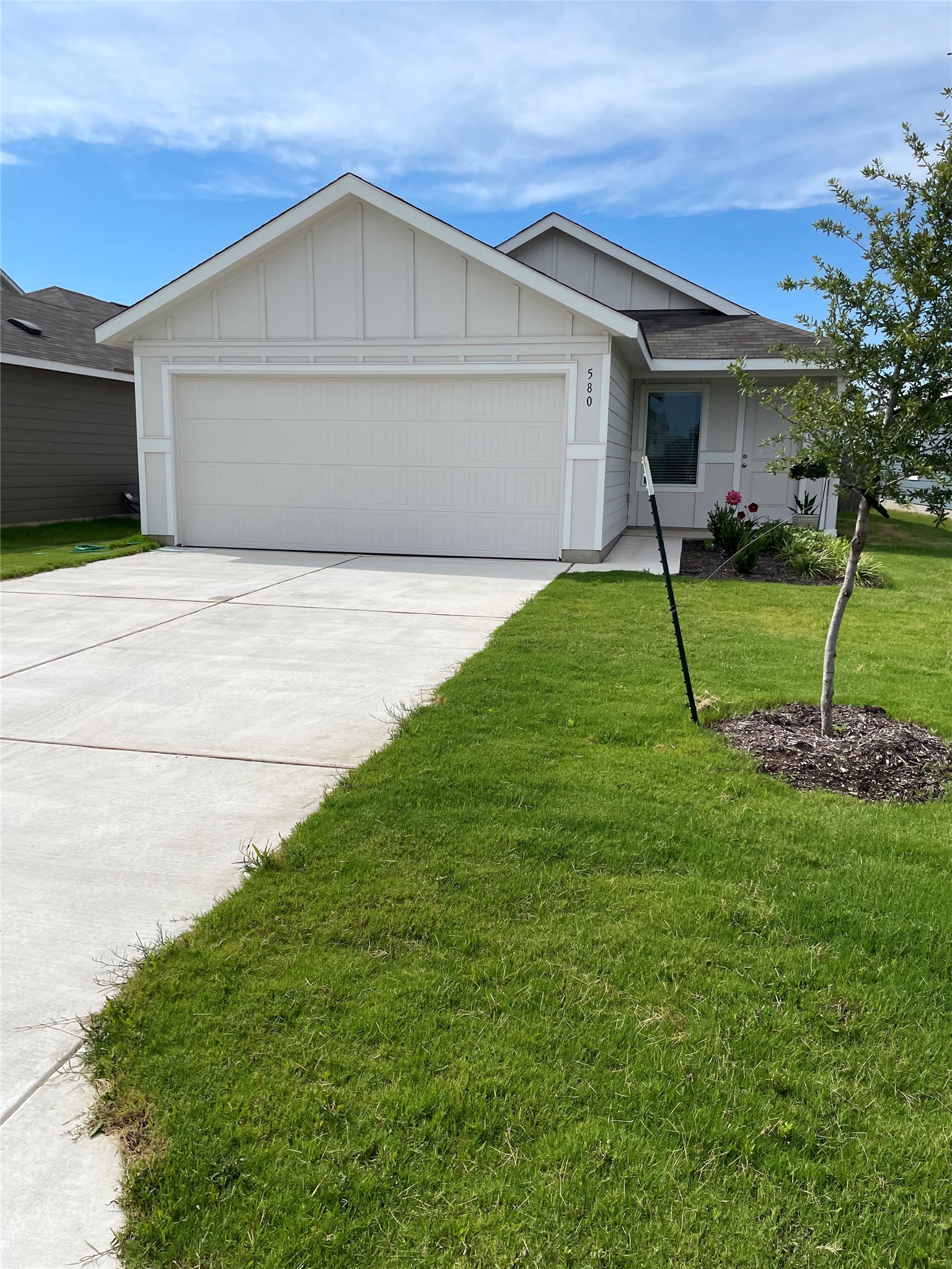 a front view of a house with a yard and trees