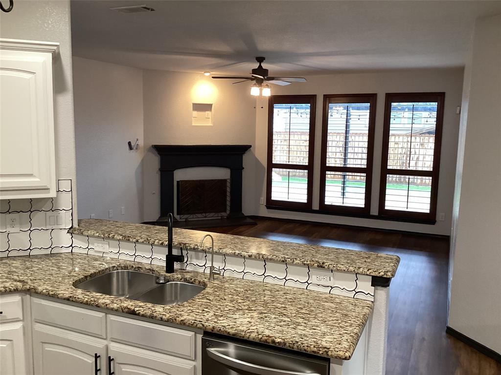 10320 Point Lobos Trail Fort Worth, TX 76177 - Photo 6 of 33 Kitchen bar with a stainless steel double sink, a matte black faucet, and a light-toned patterned countertop