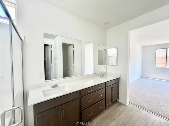 a bathroom with a double vanity sink and mirror with shower