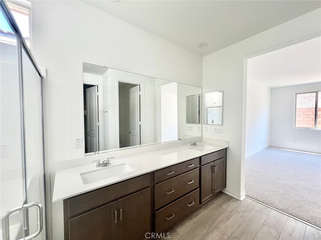 8285 Tristan Lane Riverside, CA 92507 - Photo 12 of 38 a bathroom with a double vanity sink and mirror with shower