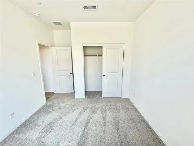 an empty room with closet and wooden floor
