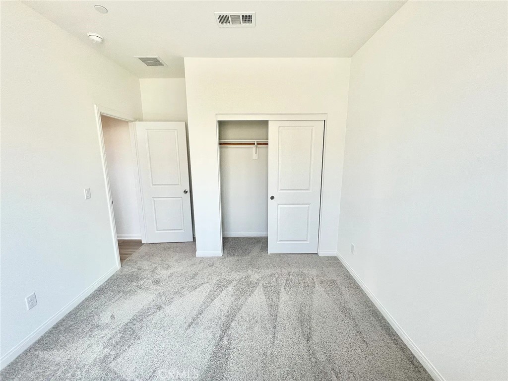 8285 Tristan Lane Riverside, CA 92507 - Photo 13 of 38 an empty room with closet and wooden floor