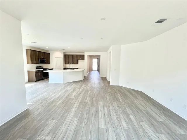 a view of living room with stainless steel appliances wooden floor and view living room