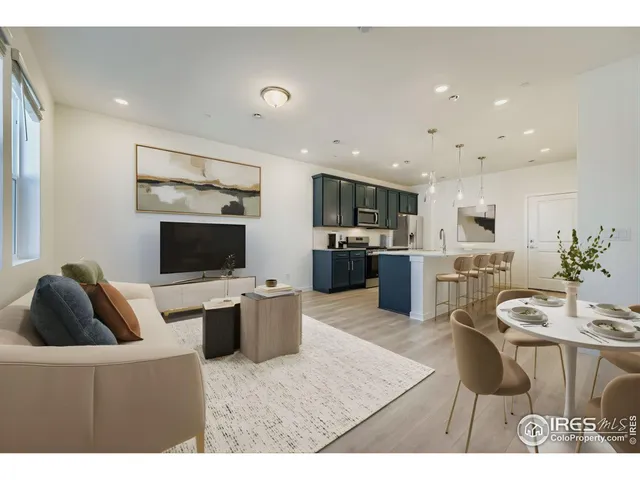 a living room with furniture a flat screen tv and kitchen view