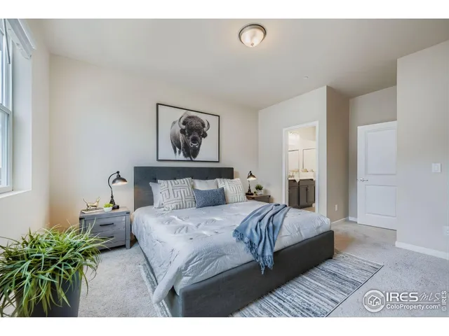 a bedroom with a bed painting on wall and a potted plant