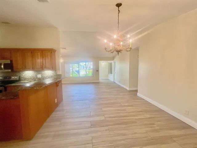 a kitchen with stainless steel appliances granite countertop a refrigerator a stove and a sink