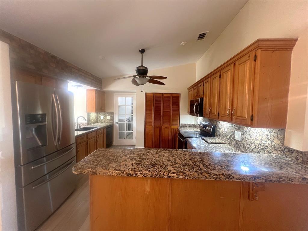 861 Southwest 55th Way Margate, FL 33068 - Photo 19 of 45 a kitchen with stainless steel appliances granite countertop a refrigerator a stove and a sink