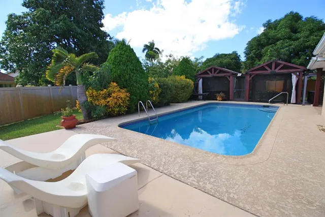 a view of a swimming pool with potted plants