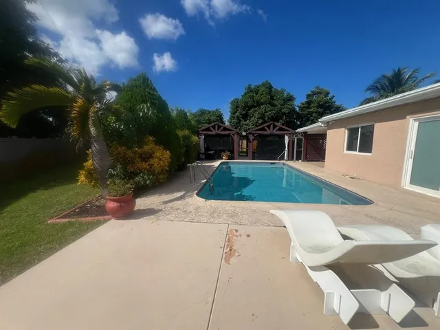a view of a house with backyard and sitting area