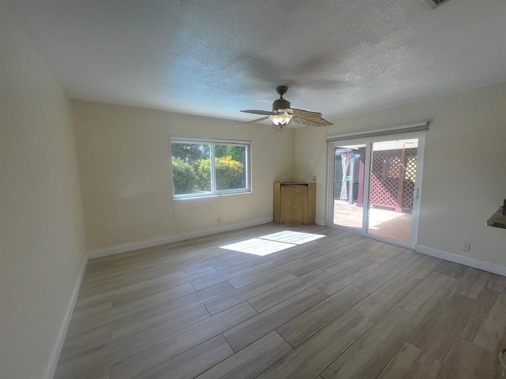 861 Southwest 55th Way Margate, FL 33068 - Photo 24 of 45 an empty room with wooden floor chandelier and windows