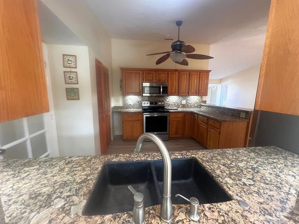 861 Southwest 55th Way Margate, FL 33068 - Photo 26 of 45 a kitchen with stainless steel appliances granite countertop a sink stove and refrigerator