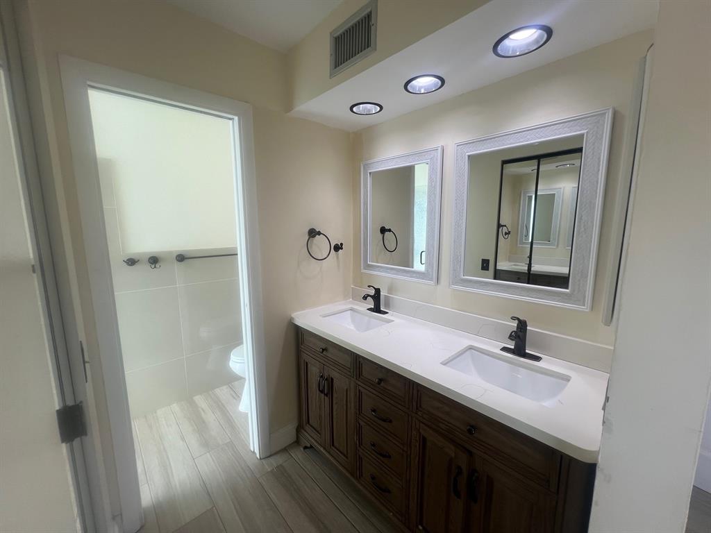 861 Southwest 55th Way Margate, FL 33068 - Photo 31 of 45 a bathroom with a double vanity sink a mirror and a shower