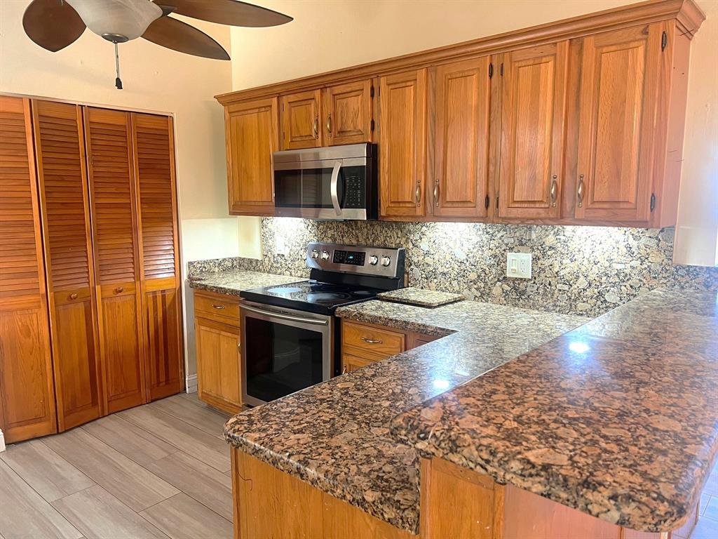 861 Southwest 55th Way Margate, FL 33068 - Photo 8 of 45 a kitchen with stainless steel appliances granite countertop a stove a sink and a microwave
