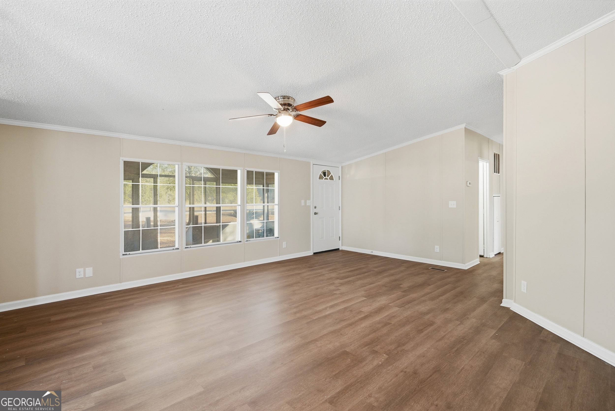 492 Doctortown Road Jesup, GA 31545 - Photo 5 of 25 a view of an empty room with wooden floor and a window
