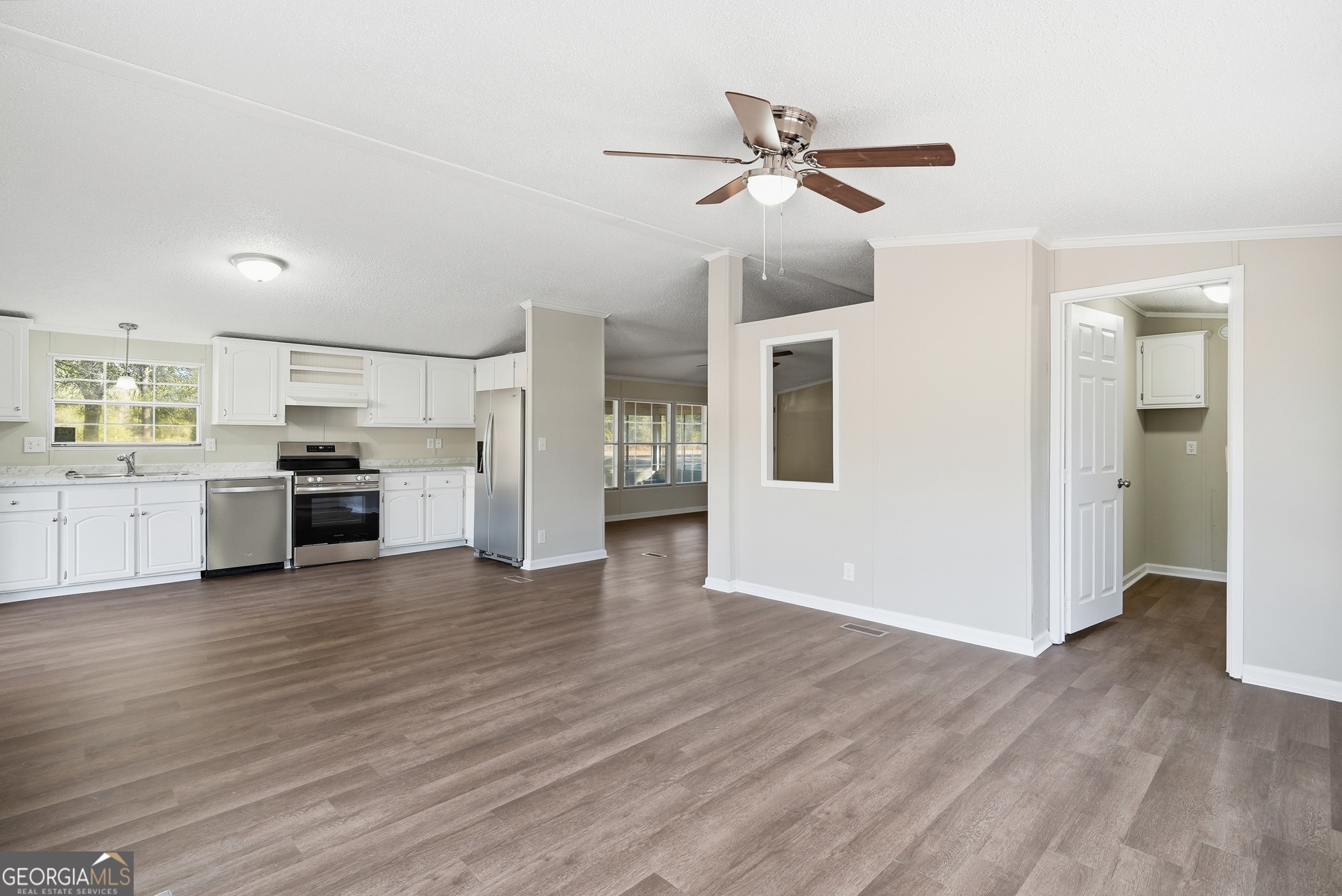 492 Doctortown Road Jesup, GA 31545 - Photo 8 of 25 a view of a kitchen with wooden floor and a ceiling fan