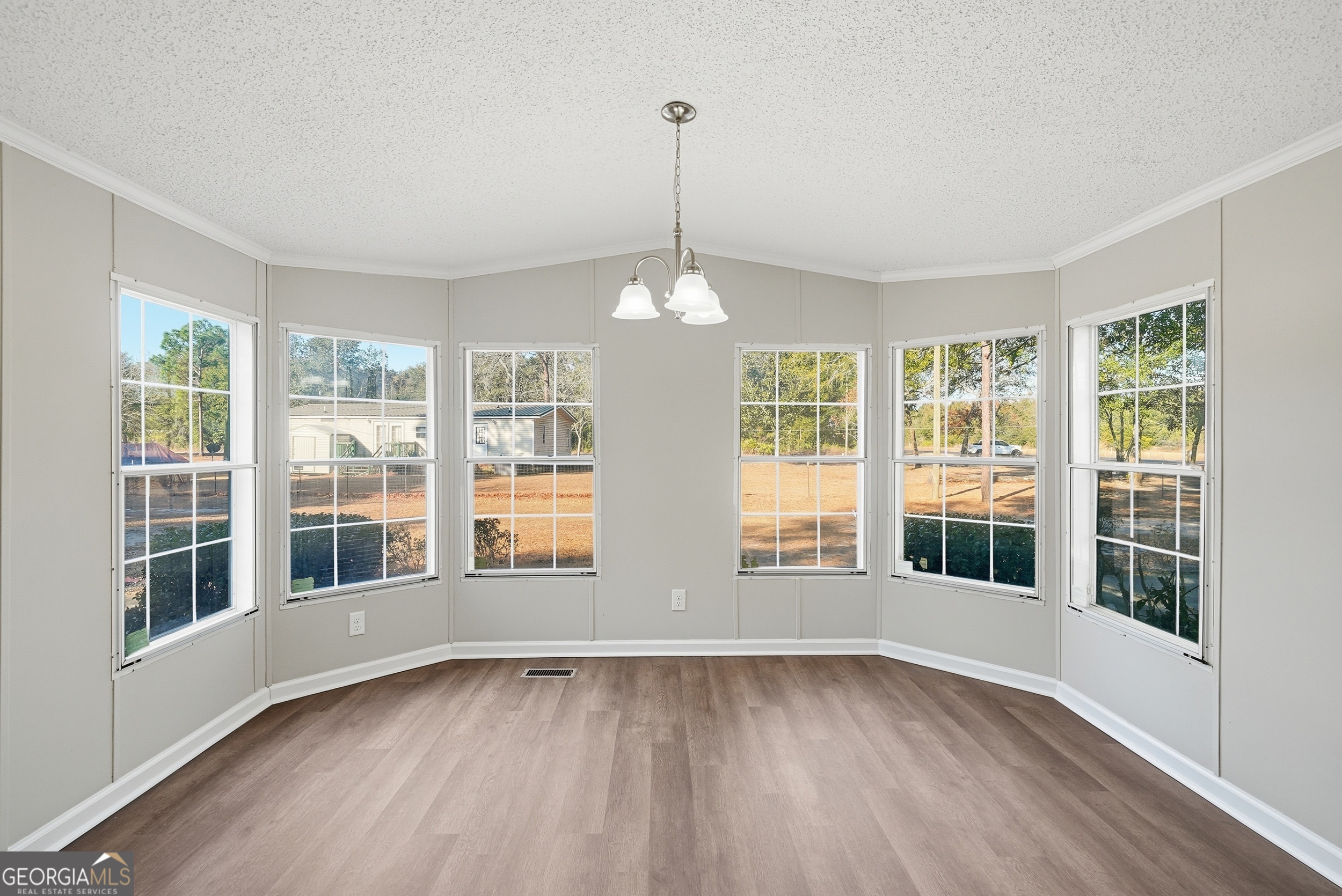 492 Doctortown Road Jesup, GA 31545 - Photo 9 of 25 a view of an empty room with wooden floor and a window