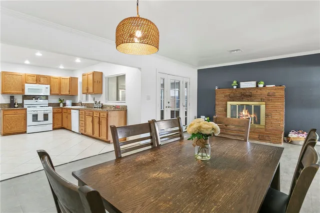 a living room with stainless steel appliances furniture a rug and a kitchen view