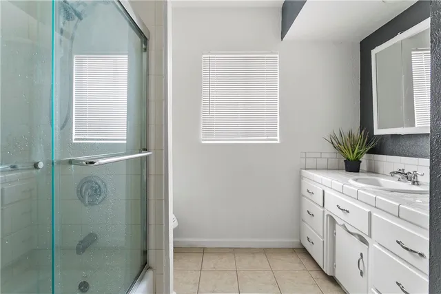 a bathroom with a shower sink and mirror