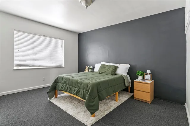 a bed sitting in a bedroom next to a window