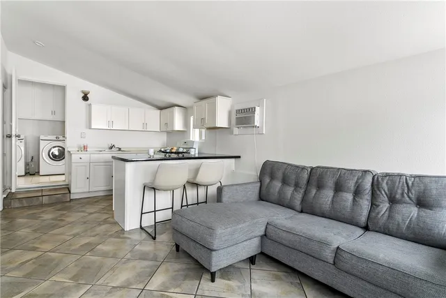a living room with furniture and kitchen view