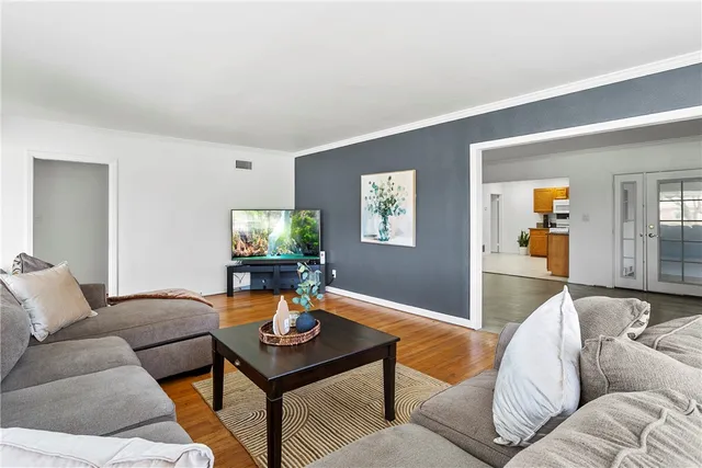 a living room with furniture and a wooden floor