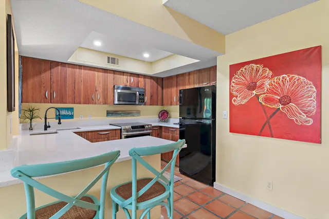 a kitchen with stainless steel appliances granite countertop a refrigerator and a stove top oven