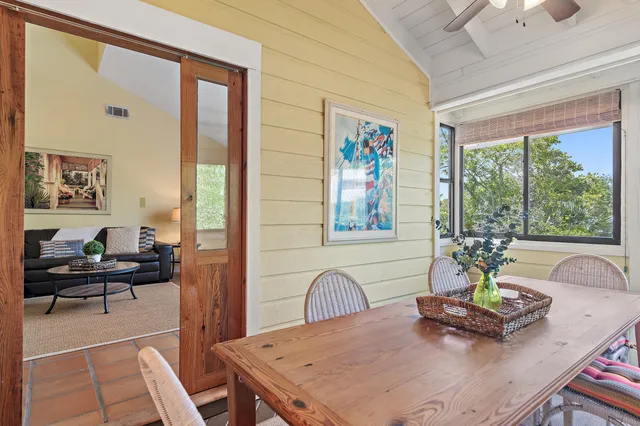 a view of a dining room with furniture a chandelier and windows