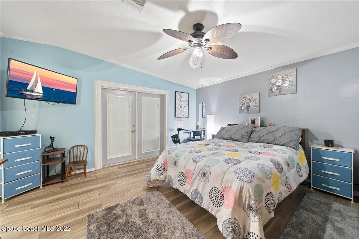 1017 Barefoot Circle Sebastian, FL 32976 - Photo 16 of 33 a bedroom with a bed and a chandelier