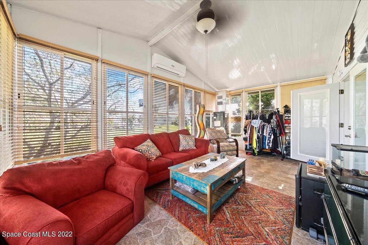 1017 Barefoot Circle Sebastian, FL 32976 - Photo 23 of 33 a living room with furniture a large window and a flat screen tv