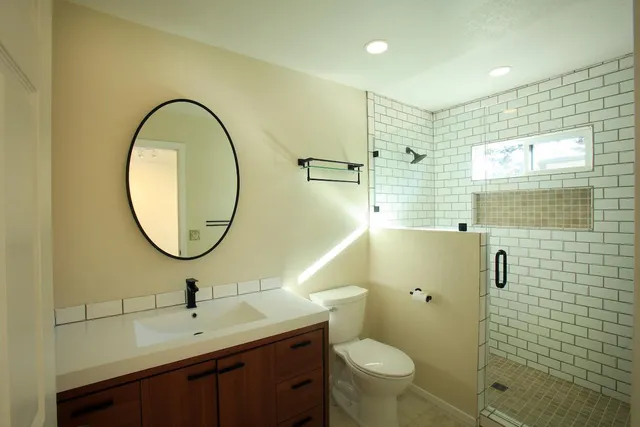 a bathroom with a sink a toilet and a mirror