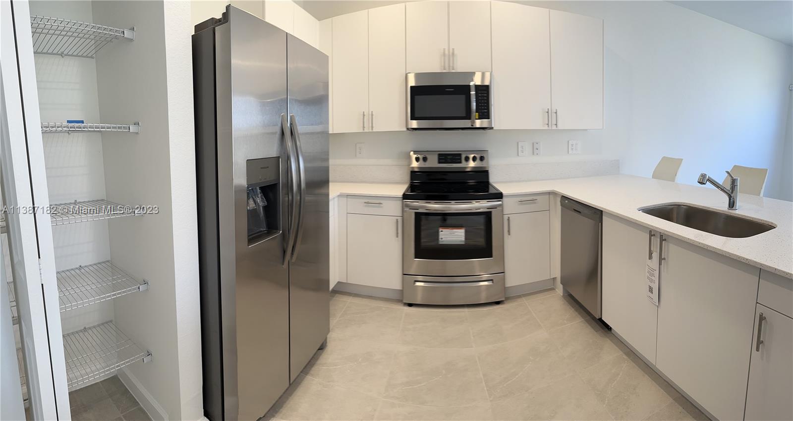 Miami-Dade County Homestead, FL 33032 - Photo 11 of 30 a kitchen with stainless steel appliances granite countertop a refrigerator sink and stove