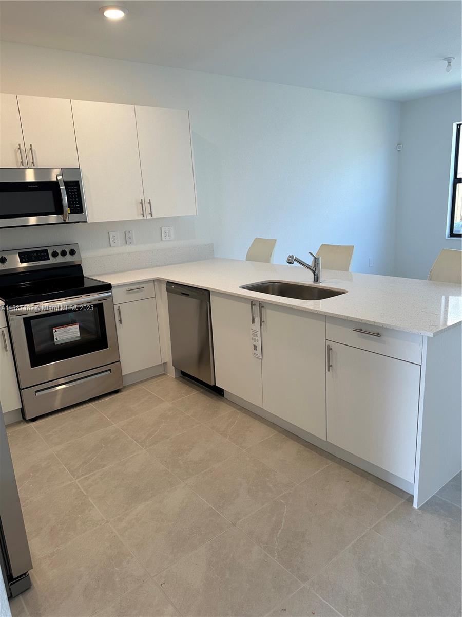 Miami-Dade County Homestead, FL 33032 - Photo 13 of 30 a kitchen with a sink and cabinets